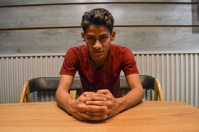 Portrait of young man sitting on table