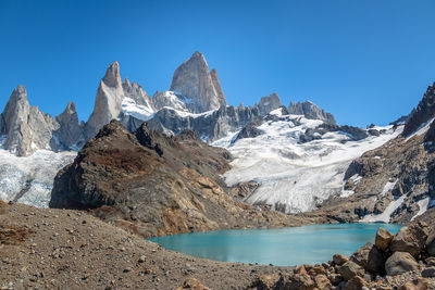 Scenic view of snowcapped mountains against clear blue sky