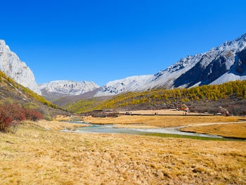 Scenic view of snowcapped mountains against clear blue sky