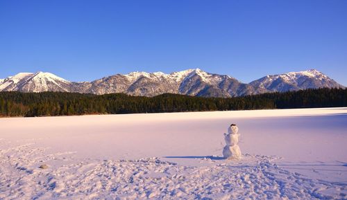 Scenic view of snowcapped mountains against clear blue sky