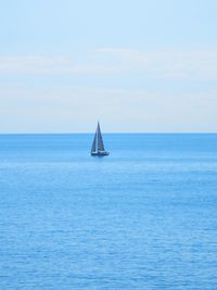 Sailboat sailing on sea against sky