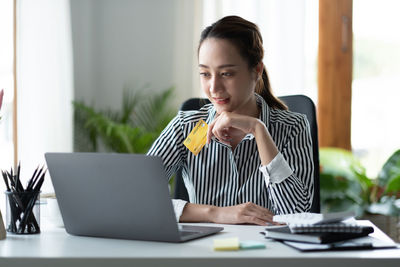 Businesswoman using laptop at office