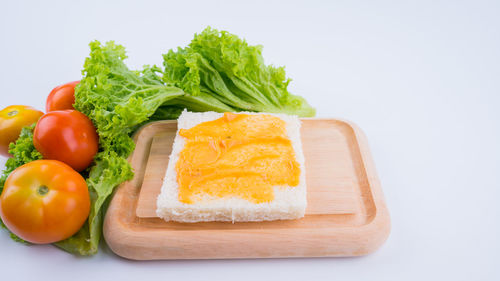 Close-up of fruits served on plate against white background