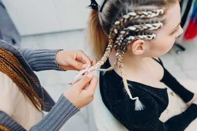 Side view of young woman applying nail