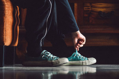 Low section of man putting on shoes