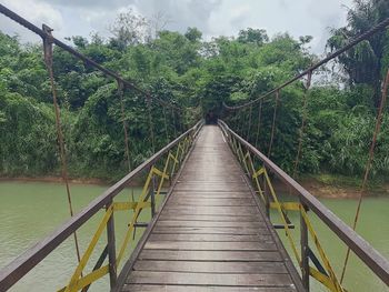 Rear view of man walking on footbridge