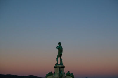 Low angle view of statue against clear sky during sunset