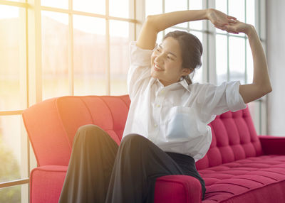 Young woman sitting on sofa at home