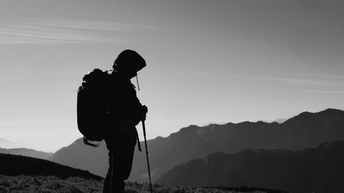 Silhouette man standing on mountain against sky