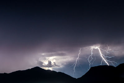 Low angle view of lightning against sky at night