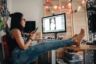 Woman using phone while sitting on table