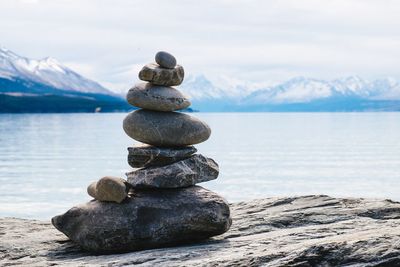 Stack of stones on beach against sky