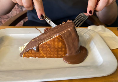 Cropped hand of person eating cake