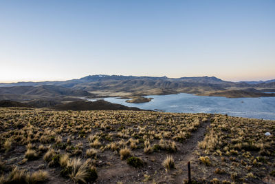 Scenic view of sea and mountains against clear sky