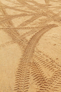 High angle view of tire tracks on sand