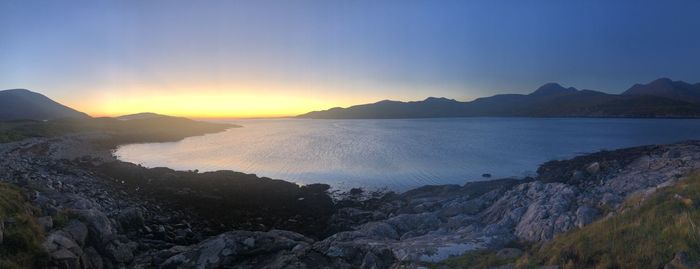 Scenic view of sea and mountains against sky during sunset