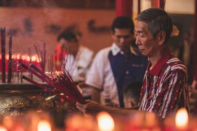 Man with illuminated candles in temple
