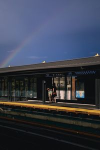 Train at railroad station in city against sky