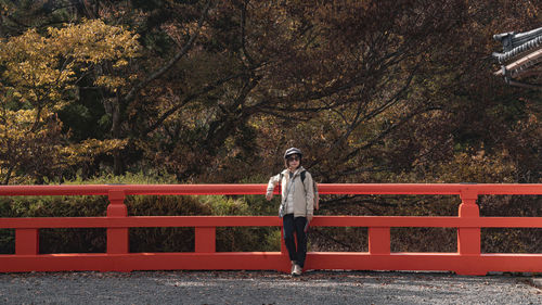 Full length of woman standing by japanese fence