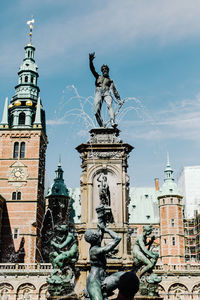 Low angle view of statue against buildings in city