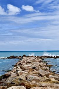 Scenic view of rocks on beach against sky