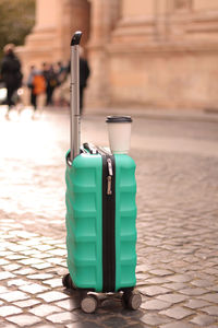 A suitcase with a cup of coffee dries up in the middle of the street