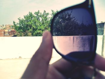 Close-up of hand on car against trees