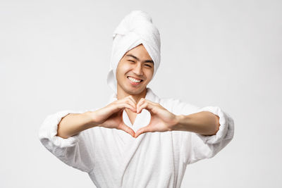 Portrait of smiling young woman against white background