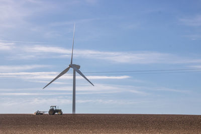 Windmill on field against sky