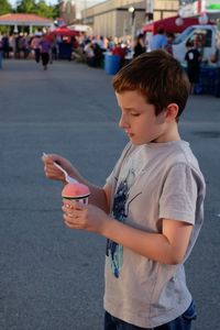 Boy holding ice cream on street