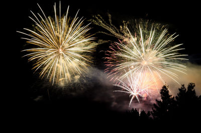 Low angle view of firework display at night