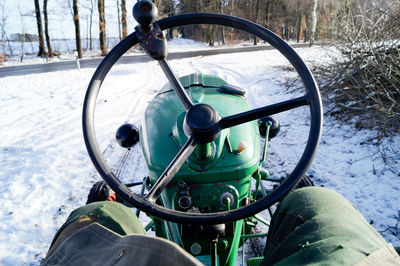 Rear view of person at old tractor in snow