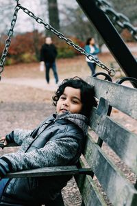 Close-up of boy sitting on bench at playground