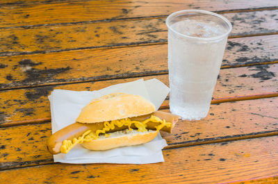 Close-up of hot dog and drink on table