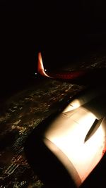 Airplane wing against sky at night
