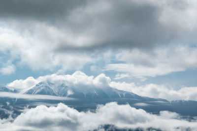 Low angle view of sunlight streaming through clouds