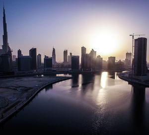 River in city against clear sky during sunset