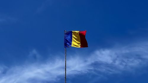 Low angle view of romanian flag against blue sky