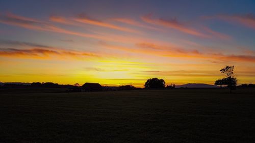 Scenic view of silhouette field against sky during sunset