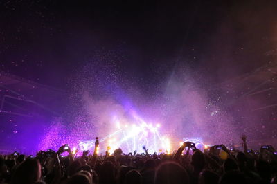 Rear view of crowd during music concert at night