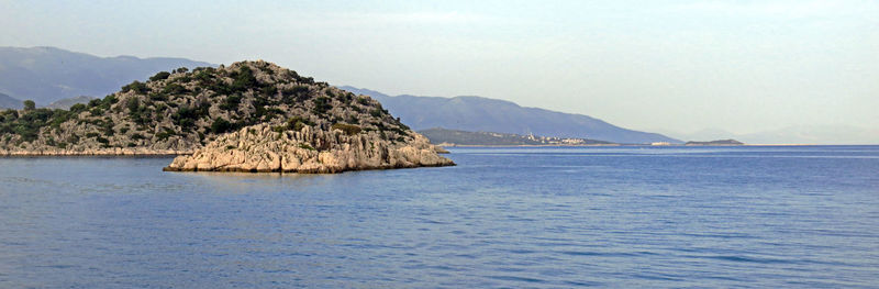 Scenic view of sea and mountains against sky