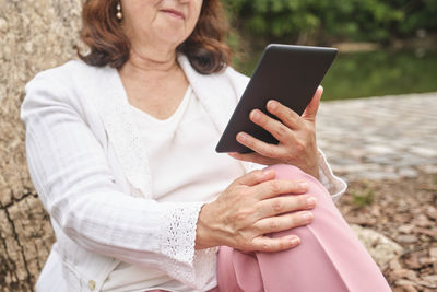 Midsection of woman using mobile phone