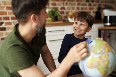 Side view of boy playing with teddy bear