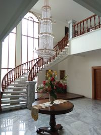 Hanging chandelier and spiral stairs with wooden rail