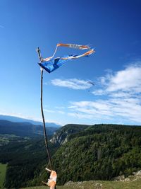 Low angle view of person on mountain against sky