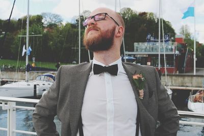 Man with eyes closed wearing suit while standing outdoors