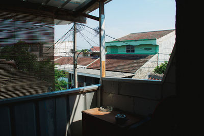 Buildings against sky seen through window