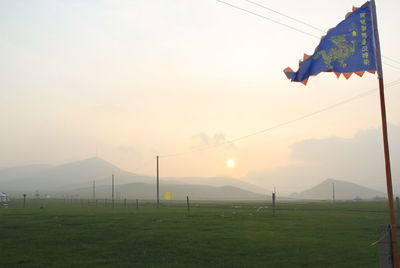 Clothes hanging on mountain against sky during sunset