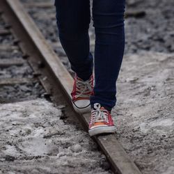 Low section of man standing on railroad track