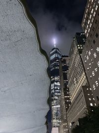 Low angle view of illuminated buildings against sky at night